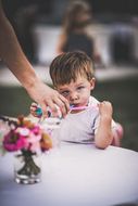 Ein kleiner Bub trinkt mit einem Strohhalm sein Glas aus