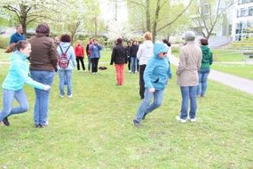 Eine Gruppe Erwachsener läuft auf der Wiese herum